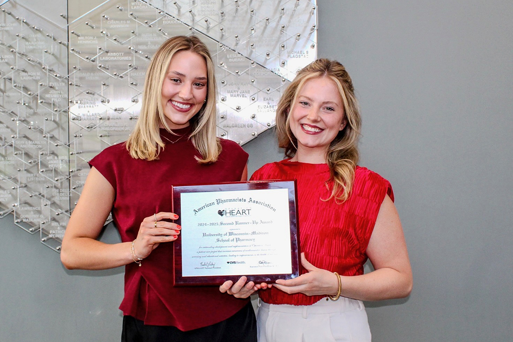 Alexis Huffman and Caitlin Cook hold an award plaque