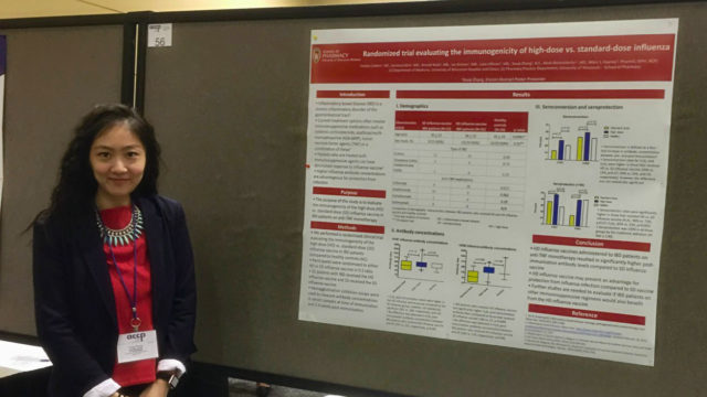 Youqi Zhang standing with her research poster