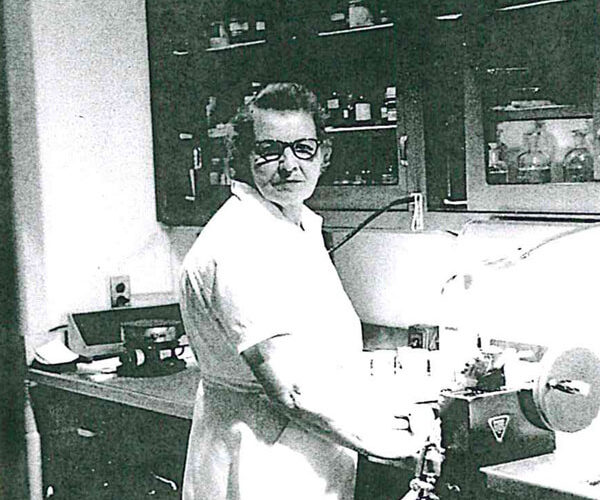 Black and white photo of Ana Apinis working in a lab