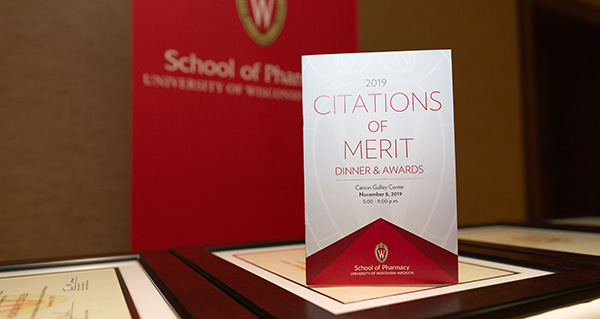 Table with program and framed award certificates at the Citations of Merit celebration