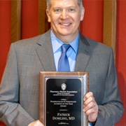 portrait of Patrick Dowling holding PharmTox Alum of the Year plaque