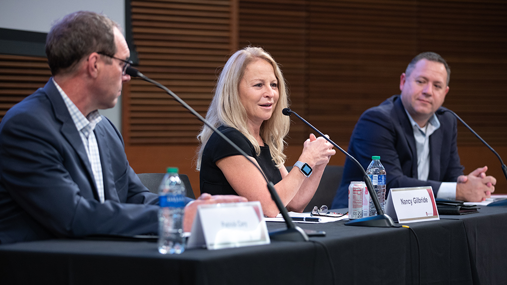 Pat Cory, Nancy Gilbride, and Brent Eberle sit at a table with microphones.