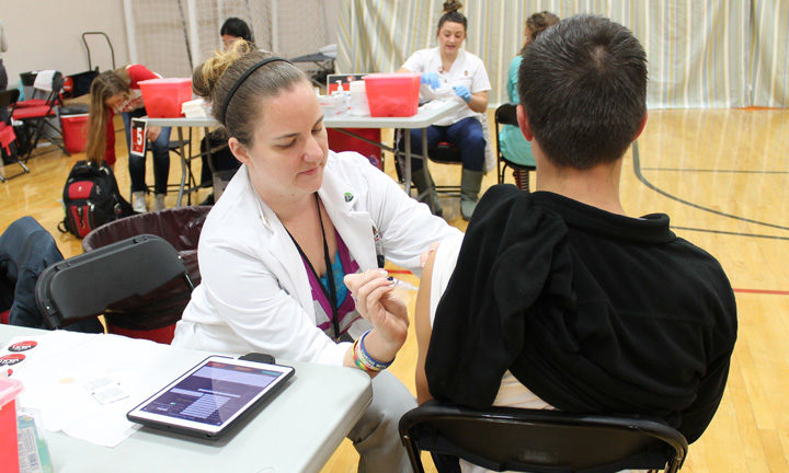 Third-year PharmD student Christina Sanchez administers the meningitis vaccine to a UW-Madison student at the SERF.