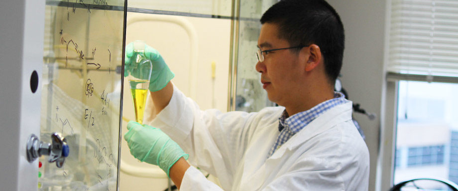MCC scientist Zhi-Xiong Ma inspects a vial in the chemical hood.