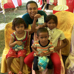 Eva Vivian poses with 3 small children during a healthcare mission to Cambodia
