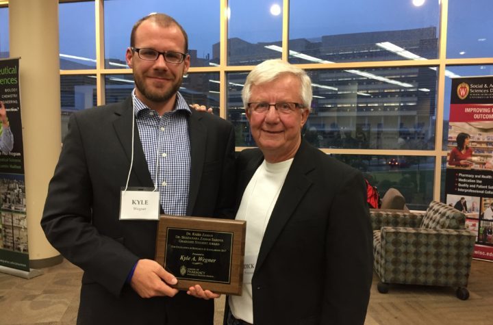 Kyle Wagner holding his award with Dick Peterson