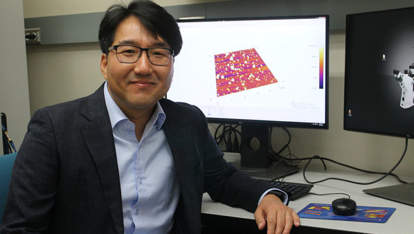 Seungpyo Hong at his desk with a 3D rendered image on his computer