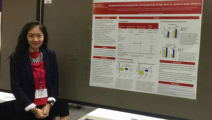 Youqi Zhang standing with her research poster