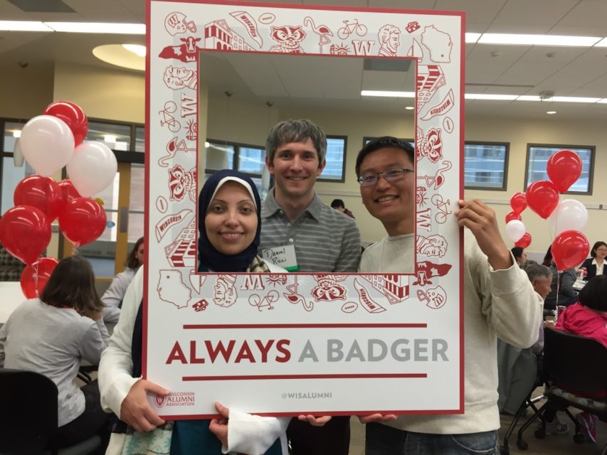 Students pose for a photograph with a frame prop.