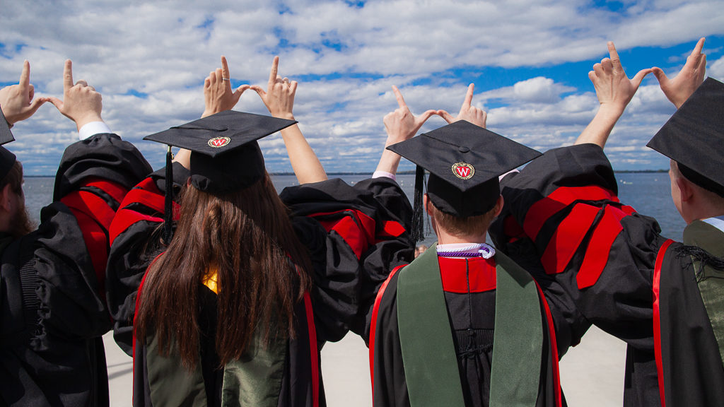 PharmD students at Hooding Ceremony holding up the "W" towards lake Mendota