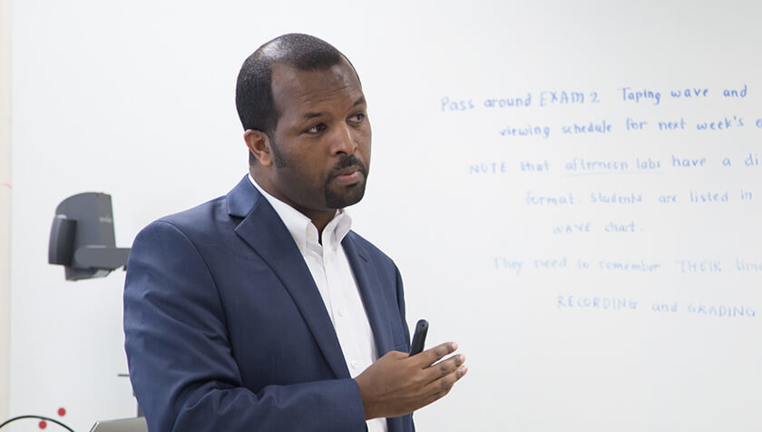 Alumnus Ephrem Abebe speaking in a classroom (MS '14, PhD '16)