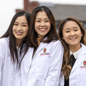 Three PharmD students outside of Memorial Union after the White Coat ceremony.