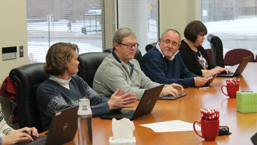 Chuck Lauhon and Mel de Villiers speaking in a meeting with campus partners