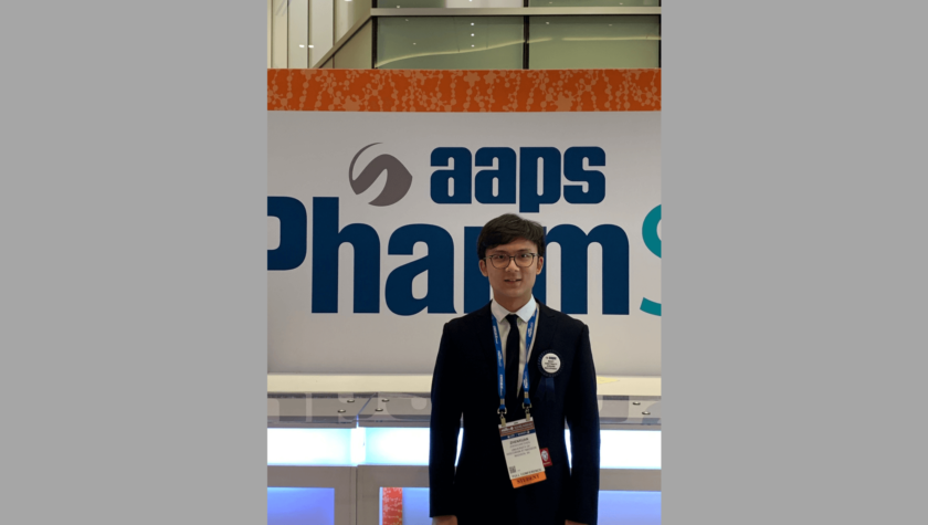 Zhenxuan Chen standing in front of 2019 AAPS PharmSci360 Conference banner