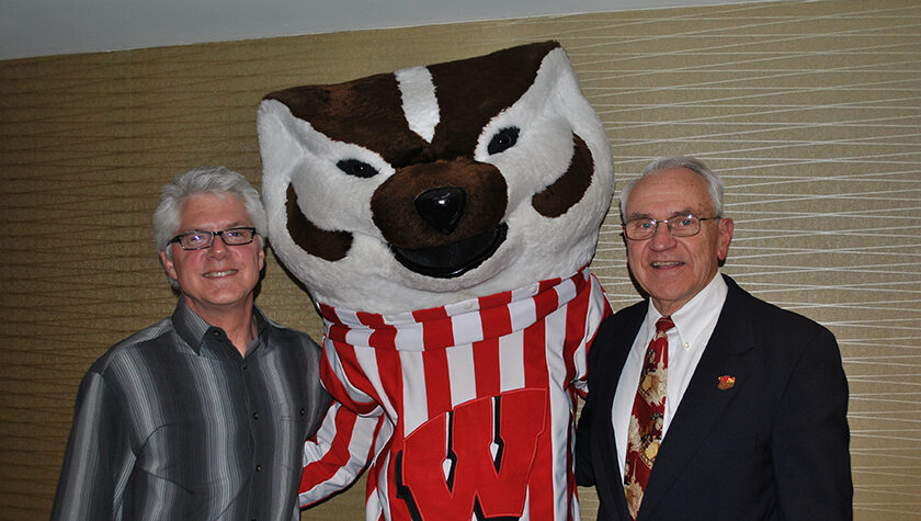 Mike Flint standing with Bucky Badger and Bill Mallatt