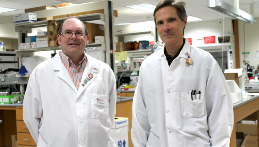 Ed Elder and Mark Sachetti wearing white coats in a lab