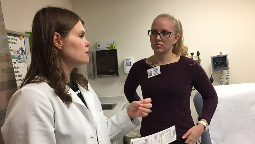 Andrea Porter working with Kelsey Eickstaedt in a doctor's office