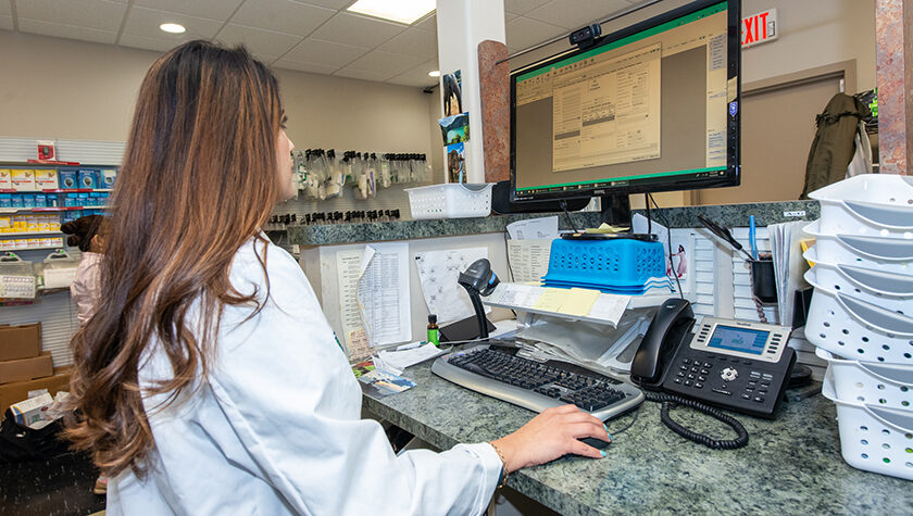 Dimmy Sokhal working at a computer in a pharmacy