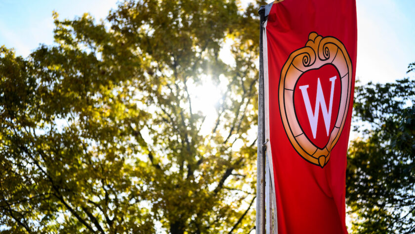 A W crest banner flutters in the wind on Bascom Hill at the University of Wisconsin-Madison during autumn