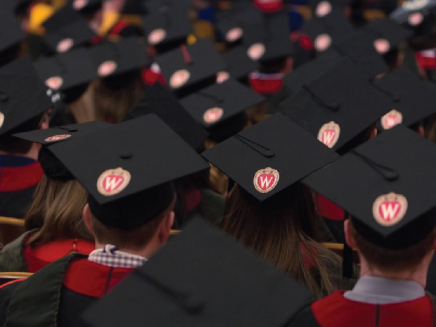 Photo of a sea of graduation hats with W crests at the graduation ceremony