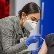 PharmD student Mahnoor Khan uses her training to vaccinate patients. Photo by Paul L. Newby II