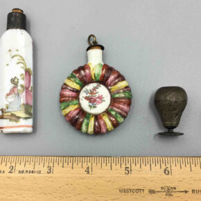 Old perfume bottles compared against ruler