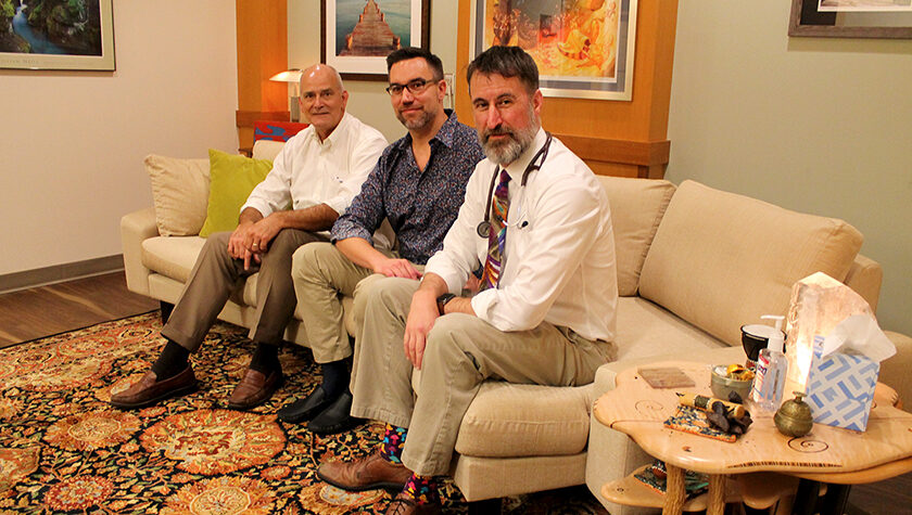 Paul Hutson, Christopher Nicholas, and Randall Brown sitting on a couch together