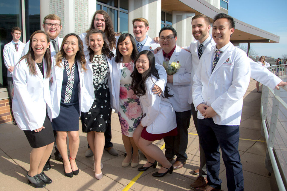 Class of 2022 PharmD students pose together with their white coats
