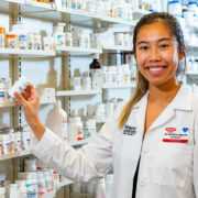 Christina Nguyen holding prescription bottle in a pharmacy