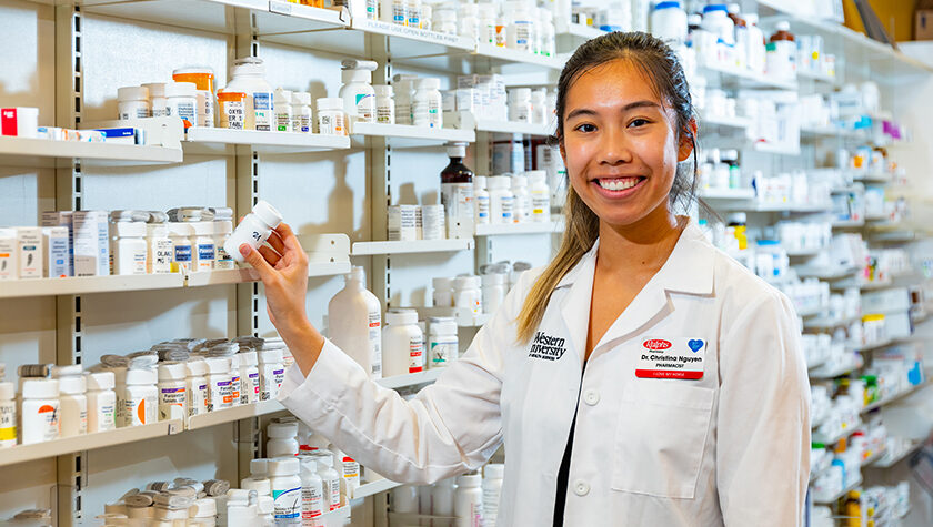 Christina Nguyen holding prescription bottle in a pharmacy