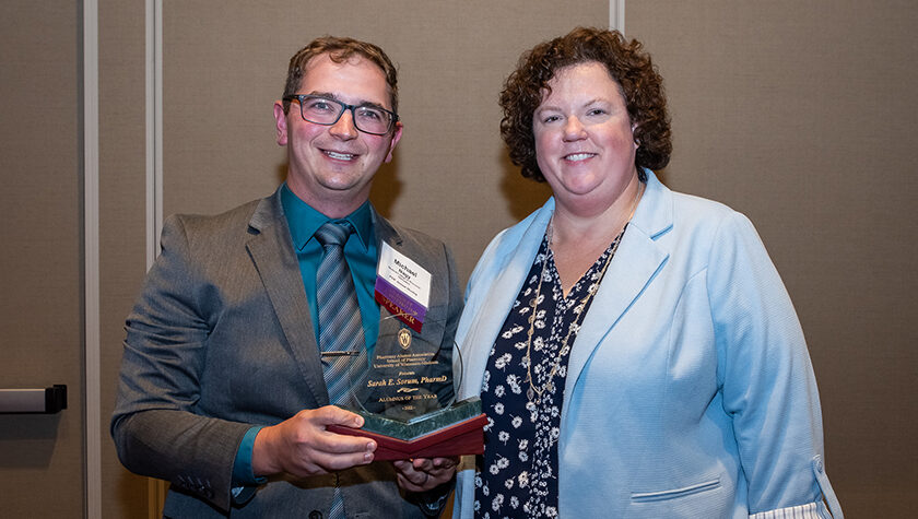 Mike Nagy and Sarah Sorum holding the Alum of the Year award