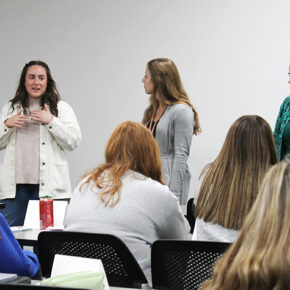 Courtney Quinn, Emma Dreischmeier, and Amanda Margolis speak in front of a class.