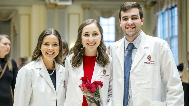 Pharmacy students Margaret Ford, Hailey Ahrens, and Brock Wehling pose together following the White Coat Ceremony. Photo by Paul Newby.