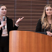 Alexis Doering and Elle Noone speaking at a podium