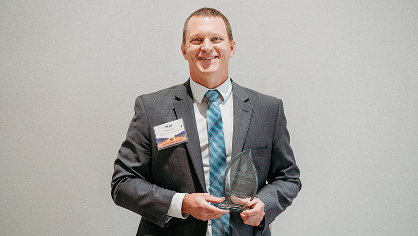 Matt McGowan holding his Young Alumnus of the Year award