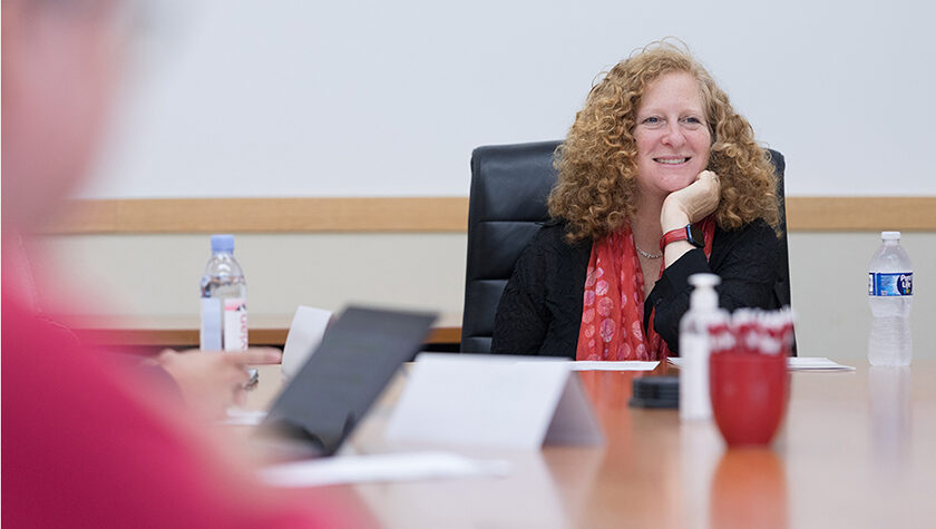 Chancellor Mnookin smiles at a board room table