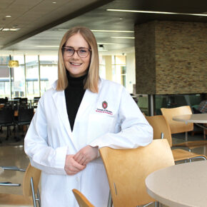 Morgan Oettinger poses for a photo in her white coat.