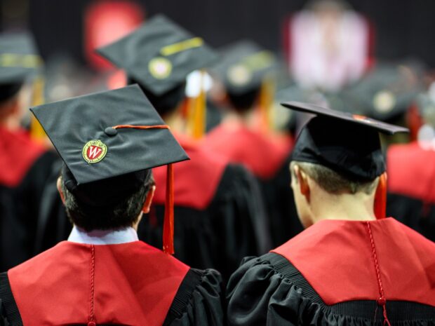 two graduating students walk in the ceremonial procession