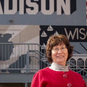 Terri Hix stands in front of a Madison mural