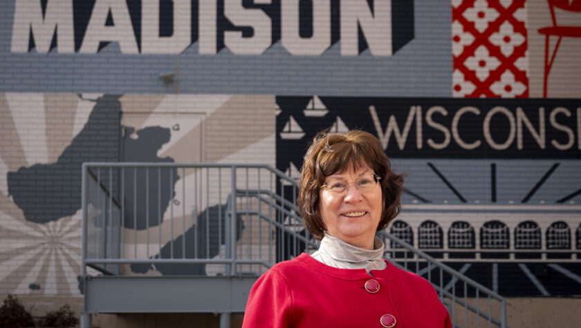 Terri Hix stands in front of a Madison mural