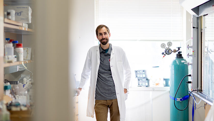 Cody Wenthur poses in his white coat in his lab