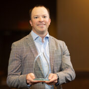 Jason Bergsbaken holds his Young Alumnus of the Year award