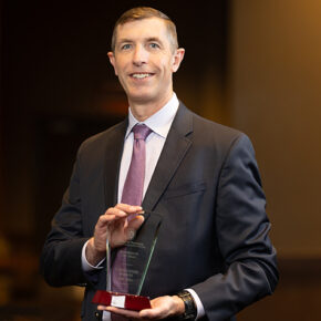 Chris Barron holds his Alum of the Year award