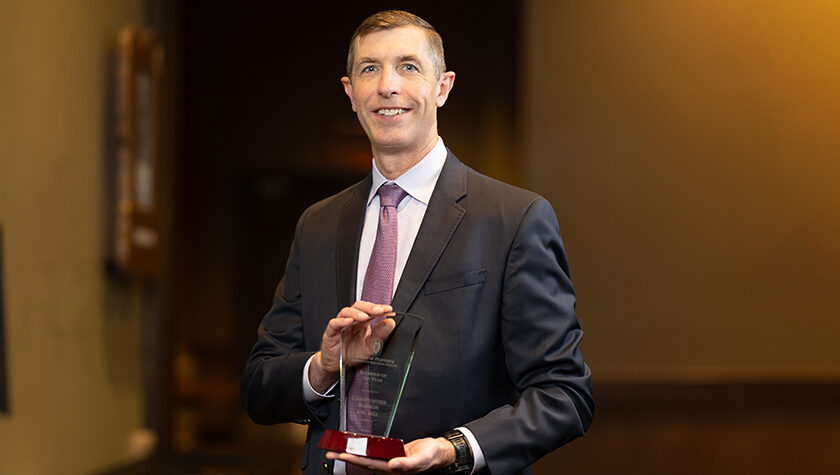 Chris Barron holds his Alum of the Year award