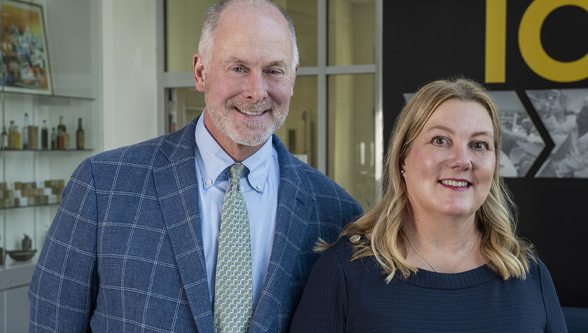 Lee Vermeulen and Jill Kolesar pose for a photo in front of a building