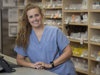 Lindsey Hoff leans on the pharmacy counter