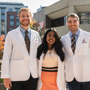 PharmD students pose outside in their white coats