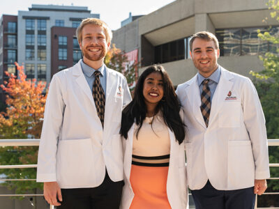 PharmD students pose outside in their white coats