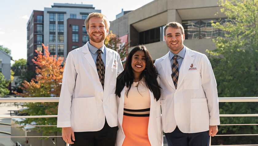 PharmD students pose outside in their white coats