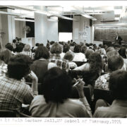 A black-and-white photo of a lecture hall full of students.